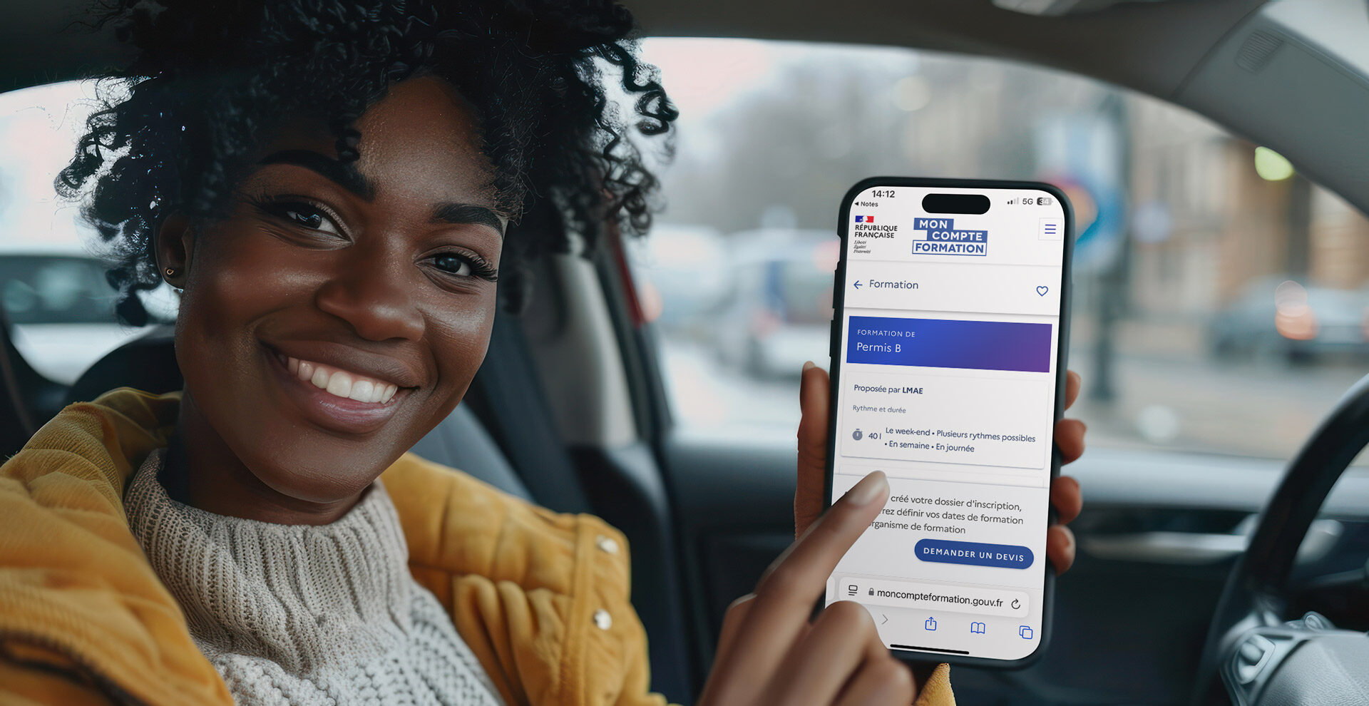 femme dans sa voiture à l'arrêt qui montre son compte de formation sur son téléphonne